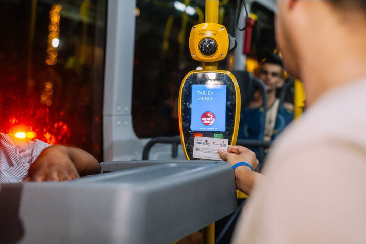 foto colorida de um homem passando o cartão em um validador de passagem de ônibus - Metrópoles