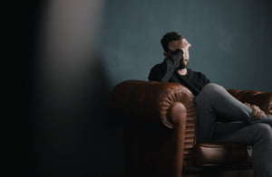 Foto colorida de homem sentado no sofá - Metrópoles