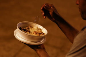 Imagem colorida mostra criança negra segurando um prato de comida; fome assola várias famílias pelo país - Metrópoles