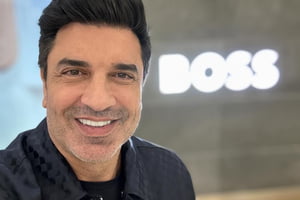 Edu Guedes posa sorridente para as redes sociais com a palavra 'boss' ao fundo - Metrópoles