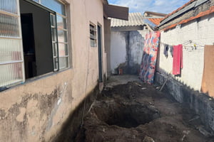 Imagem colorida mostra buraco no quintal de uma casa em Taubaté onde uma mulher foi encontrada morta - Metrópoles