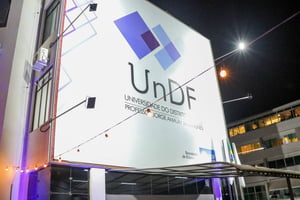 Foto colorida tirada à noite de placa de prédio iluminada por luzes escrito: UnDF