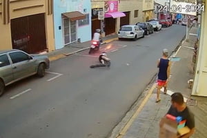 Imagem colorida mostra mulher caída na rua após ser atropelada por um motociclista - Metrópoles