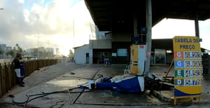 Foto colorida de posto de combustível destruído após invasão de carro