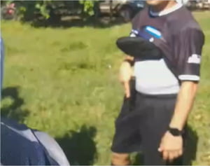 Foto colorida do PM segurando armar durante partida de futebol em que era árbitro - Metrópoles