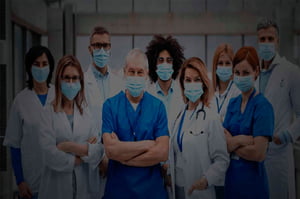 Fotografia colorida mostrando nove profissionais de saúde de braços cruzados-Metrópoles