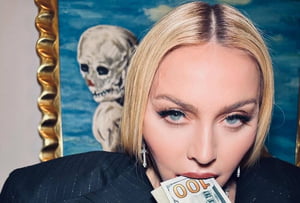 Foto colorida de Madonna comendo dinheiro - Metrópoles