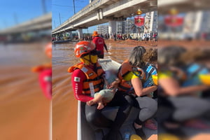 Foto colorida de bombeiros com resgate em barco
