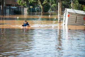 homem é visto com águas na cintura após a enchente do Rio Guaíba inundarem as ruas da cidade de Porto Alegre no Rio grande do Sul RS - Metrópoles