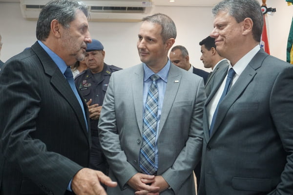 Imagem colorida mostra Osvaldo Nico conversando com o secretário Derrite e o governador Tarcísio