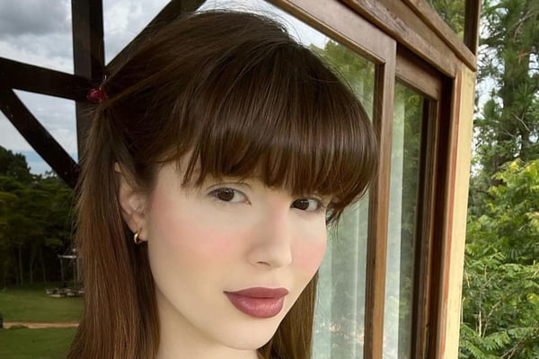 Foto colorida do rosto de uma mulher branca, com batom vinho, de cabelo castanho - Metrópoles