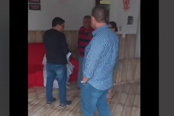 Três homens e mulher em garagem de residência - Metrópoles