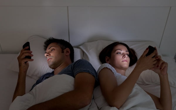 Casal no celular deitado na cama, sexo