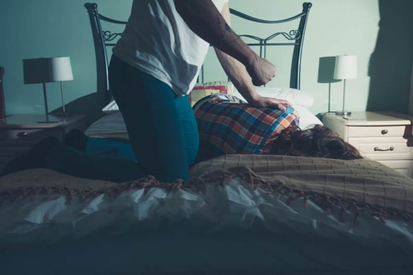 Man abusing his wife on a bed