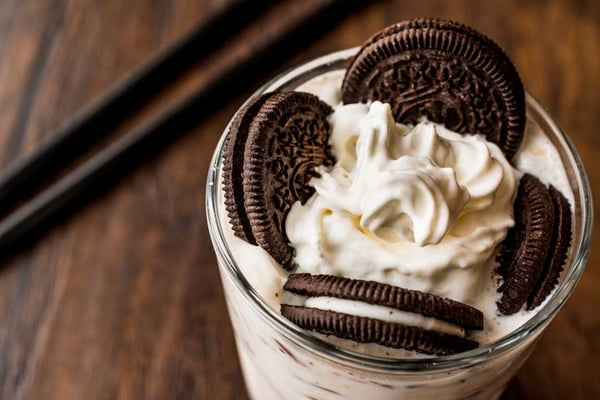 Vanilla Milkshake with chocolate cookies and black straw.