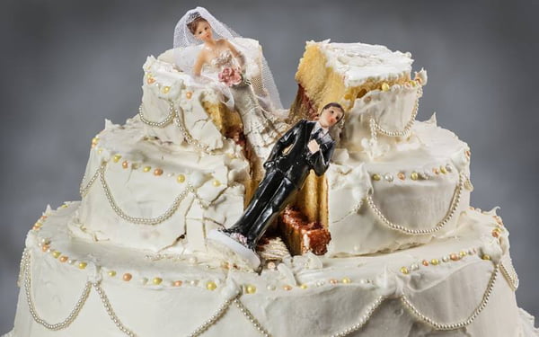 Bride and groom figurines collapsed at ruined wedding cake