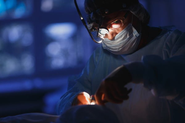 Doctor performing surgery in a dark blue background