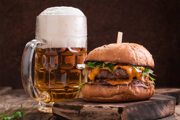 Fresh hamburger with a beer on a wooden table.