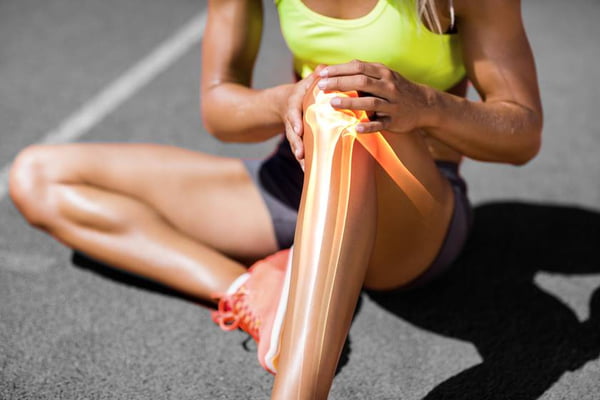 Low section of sportswoman suffering from knee pain