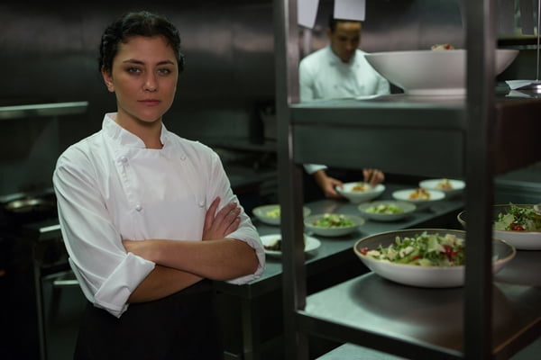 Portrait of female chef standing with arms crossed