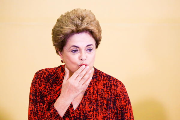 Dilma Rousseff, em foto colorida, com a mão na boca, como se estivesse mandando um beijo -- Metrópoles
