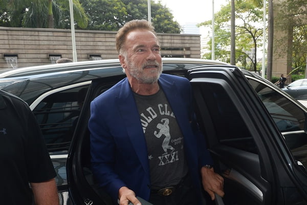 foto colorida de Arnold Schwarzenegger saindo de carro - Metrópoles