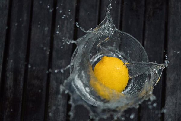 limão caindo em copo de água