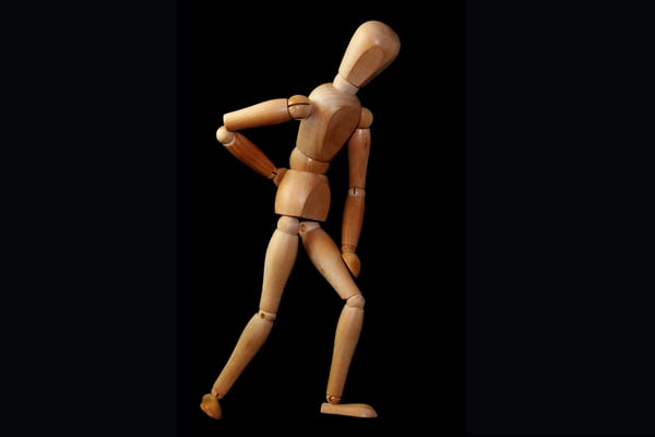 Fotografia mostra boneco articulado com uma mão nas costas e outra no joelho - Metrópoles