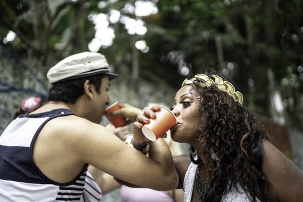 Friends having fun and drinking at street carnival party in Brazil