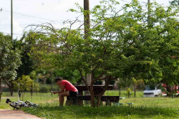 Pessoa sentada em banco no Taguaparque, em Taguatinga
