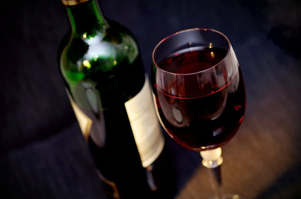 Taça de vinho tinto ao lado da garrafa
