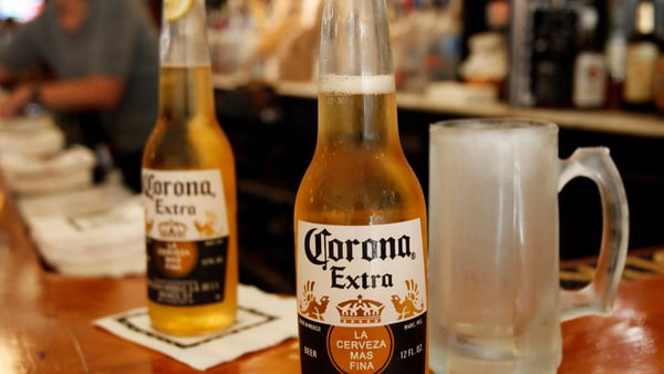 Cerveja Corona em cima de um balcão com uma caneca de chope do lado