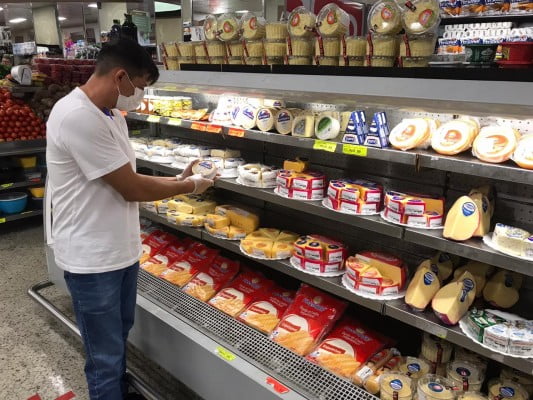 Homem escolhe produto no supermercado