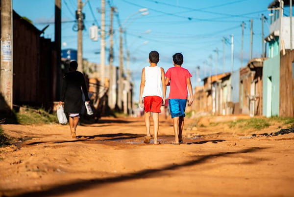 Crianças caminham em rua de terra - Metrópoles