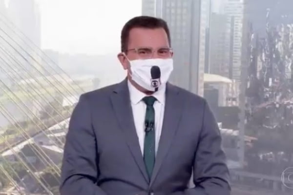 Rodrigo Bocardi de máscara com microfone da Globo