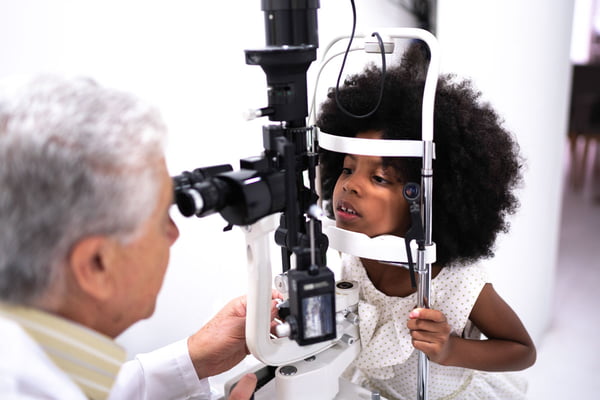 crianca faz exame de vista com oftalmologista