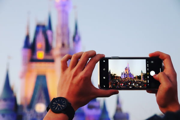 Pessoa tira foto do castelo da Cinderela, na Disney