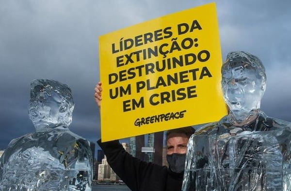 Ativista do Greenpeace com esculturas de gelo de Bolsonaro e TRump