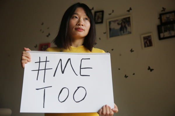 Sophia Huang Xueqin posa com um cartaz #MeToo em sua casa