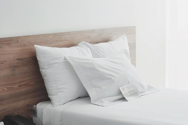 cama com colchão e travesseiros brancos