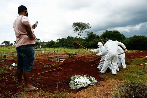coveiros de cemitério municipal, em goiânia, goiás, enterram vítima de covid-19. rotina cansativa