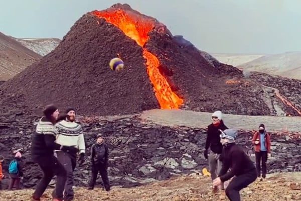 grupo joga vôlei abaixo de vulcão em erupção