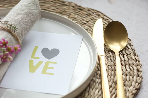 Prato e talheres montados para jantar com cartão escrito love