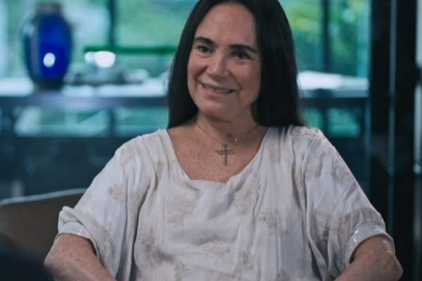 Foto colorida de Regina Duarte sorrindo e usando blusa branca - Metrópoles