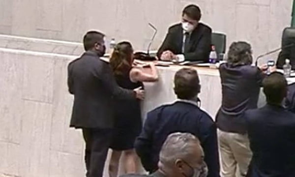 Imagem colorida mostra o deputado Fernando Cury, de terno preto, abraçando a deputada Isa Penna, de vestido preto, pelas costas e posiciona sua mão direita sobre o seio direito dela. os dois estão de costas, em pé - Metrópoles