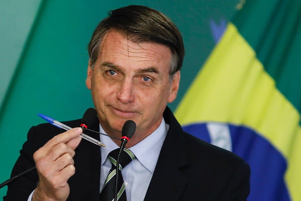 Jair Bolsonaro segura caneta - Metrópoles
