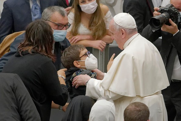 Criança sube em palco do papa