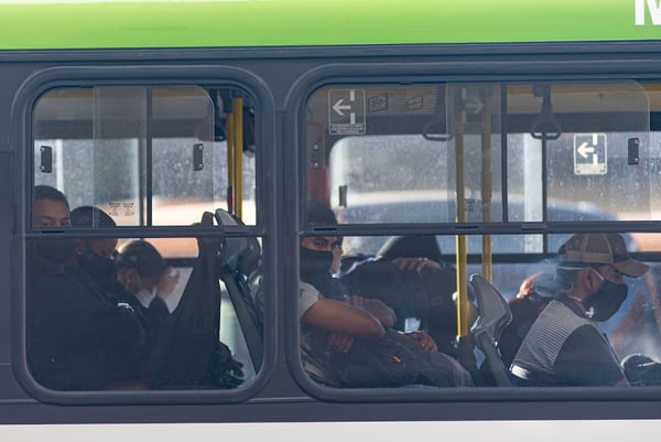 Pessoas utilizando máscara dentro de ônibus