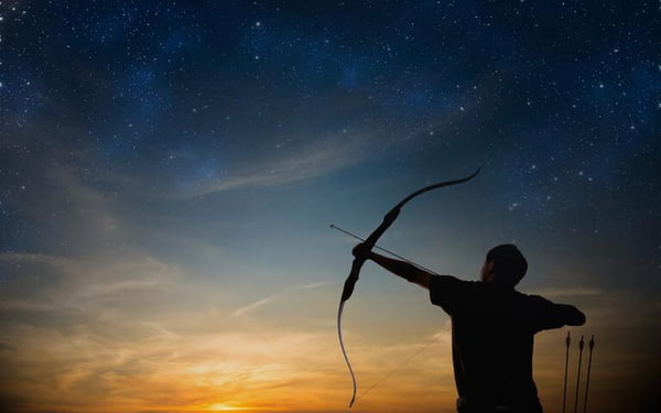 A imagem mostra um homem com arco e flecha apontado para o céu