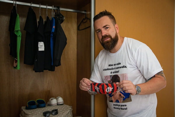 Leniel Borel, pai de Henry, segura máscara do Flamengo usada pelo menino